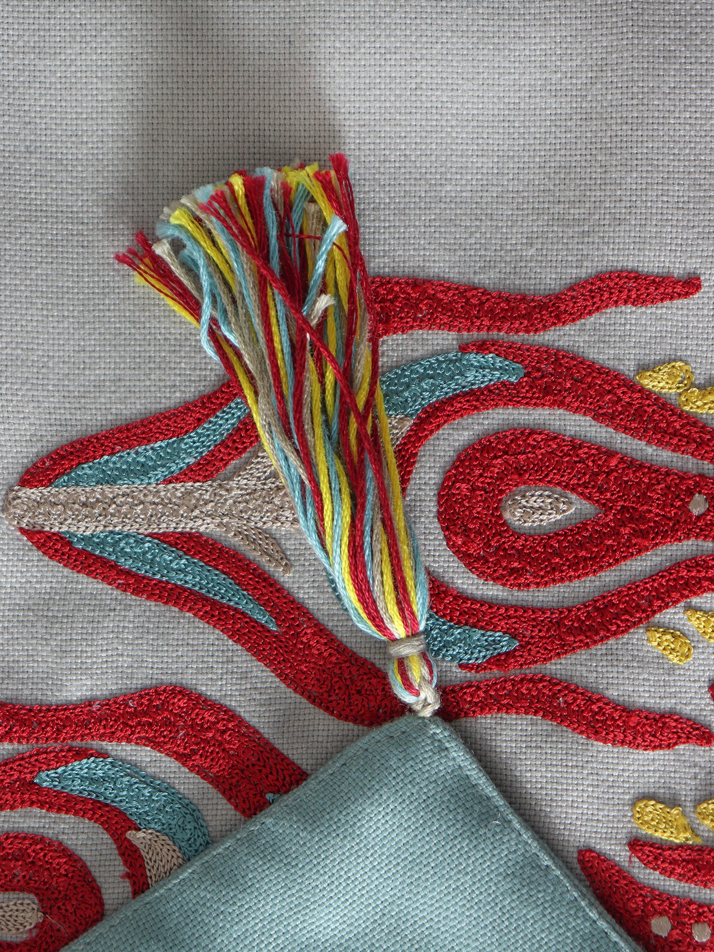 closeup of tassels and red colored hand embroidery of 6 seater table runner - 12x84