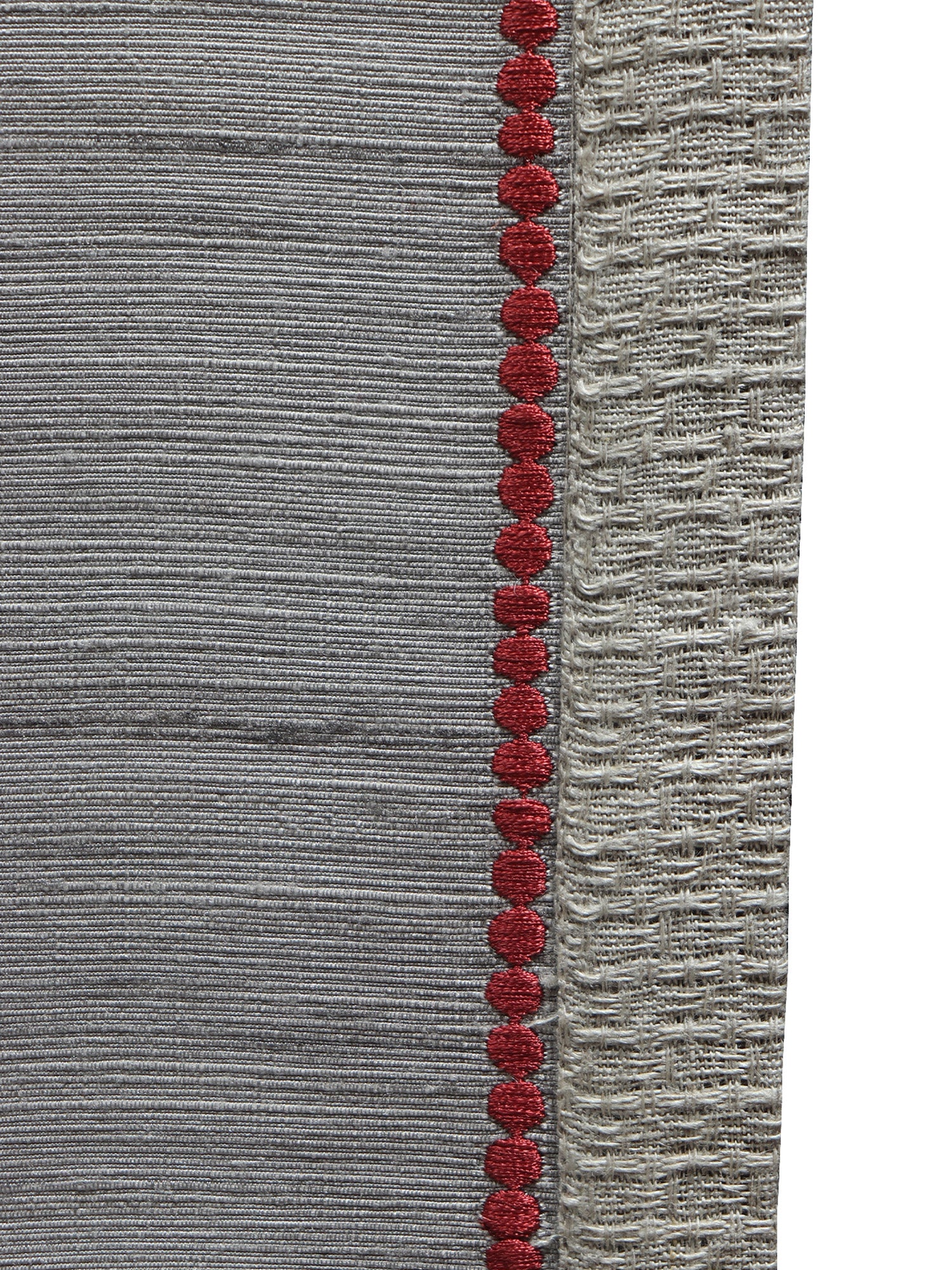 closeup of red embroidery on gray table runner