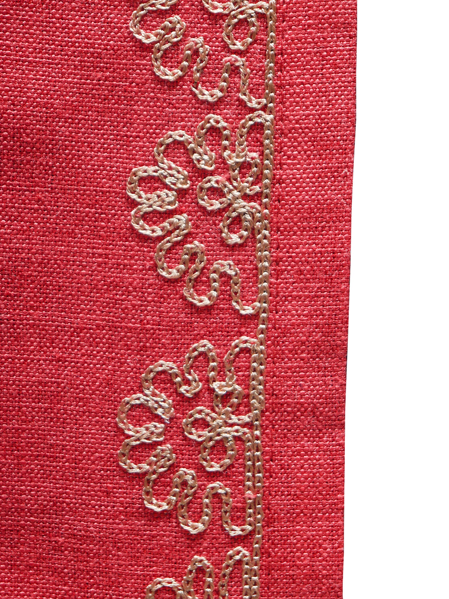 closeup of golden embroidery on red colored tablerunner 