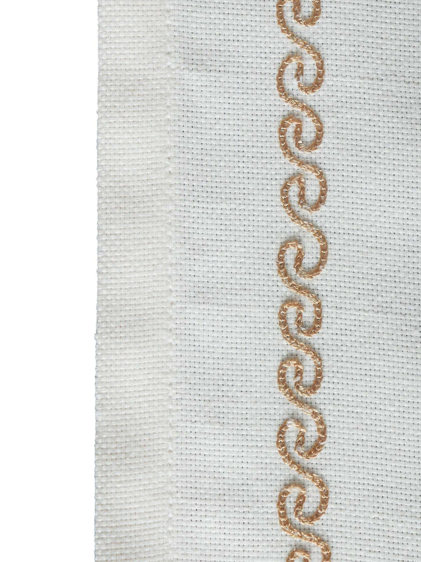 wavy patterned embroidery in golden color on an offwhite table runner