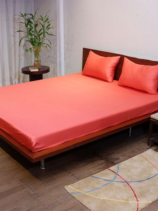 side view of coral pink colored plain soft bedsheet with 2 matching pillow covers made from 100% pure cotton for king size double bed in 108x108inches