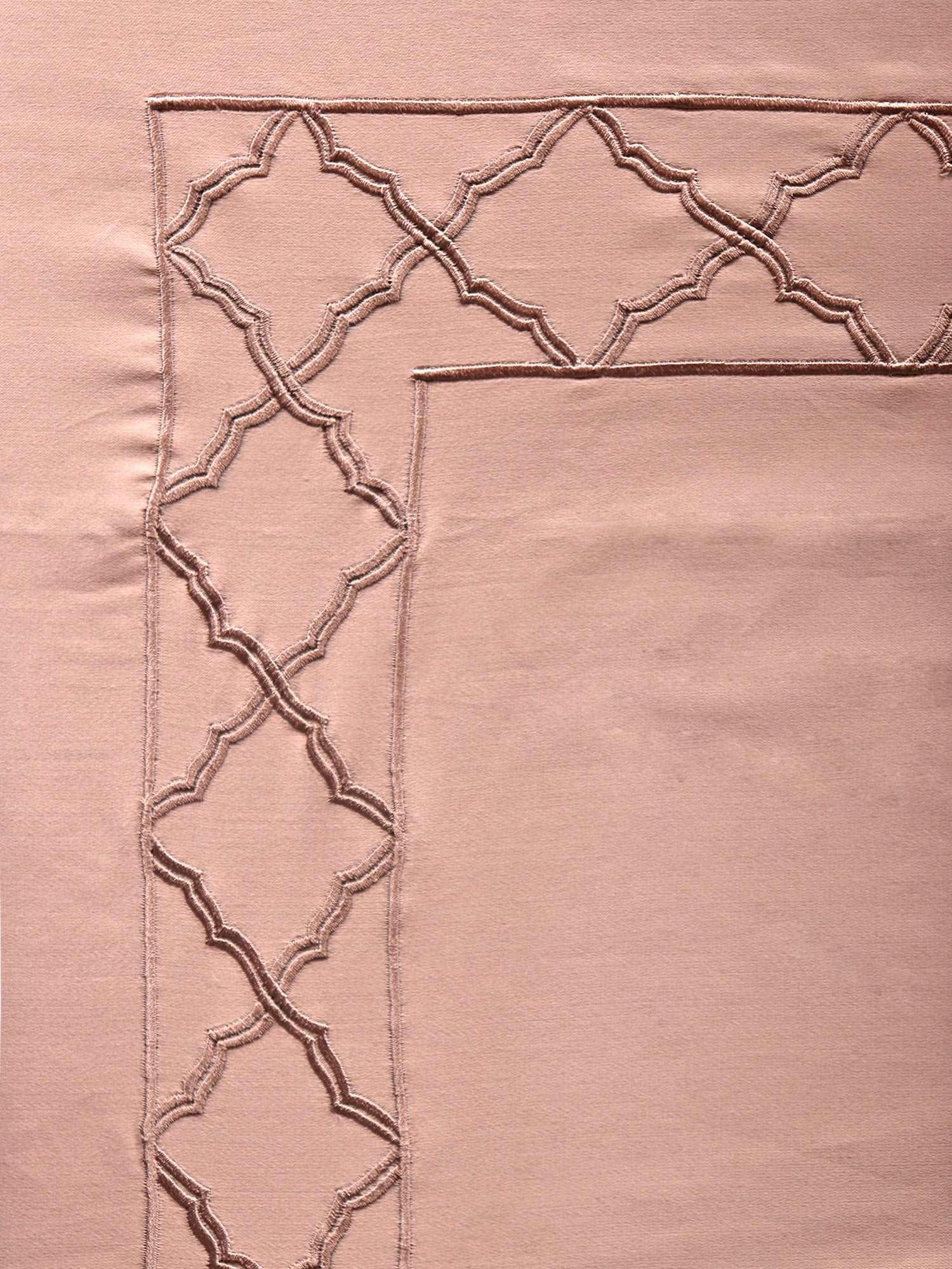 close up of Blush pink colored embroidered soft bedsheet with 2 matching embroidered pillow covers made from 100% pure cotton for king size double bed in 700 thread count fabric