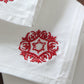 close up of motif embroidered in red color on white colored set of 6 dinner napkins - 16x16 inch