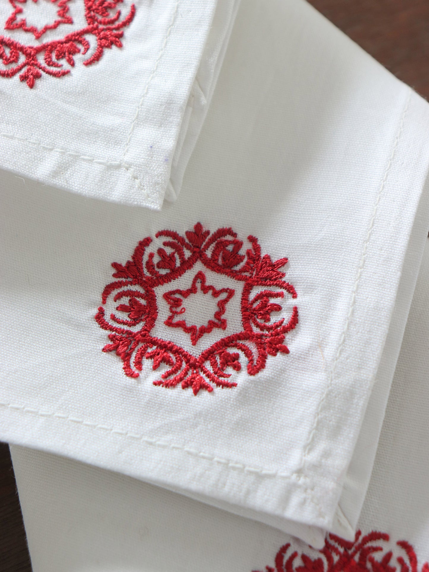 close up of motif embroidered in red color on white colored set of 6 dinner napkins - 16x16 inch