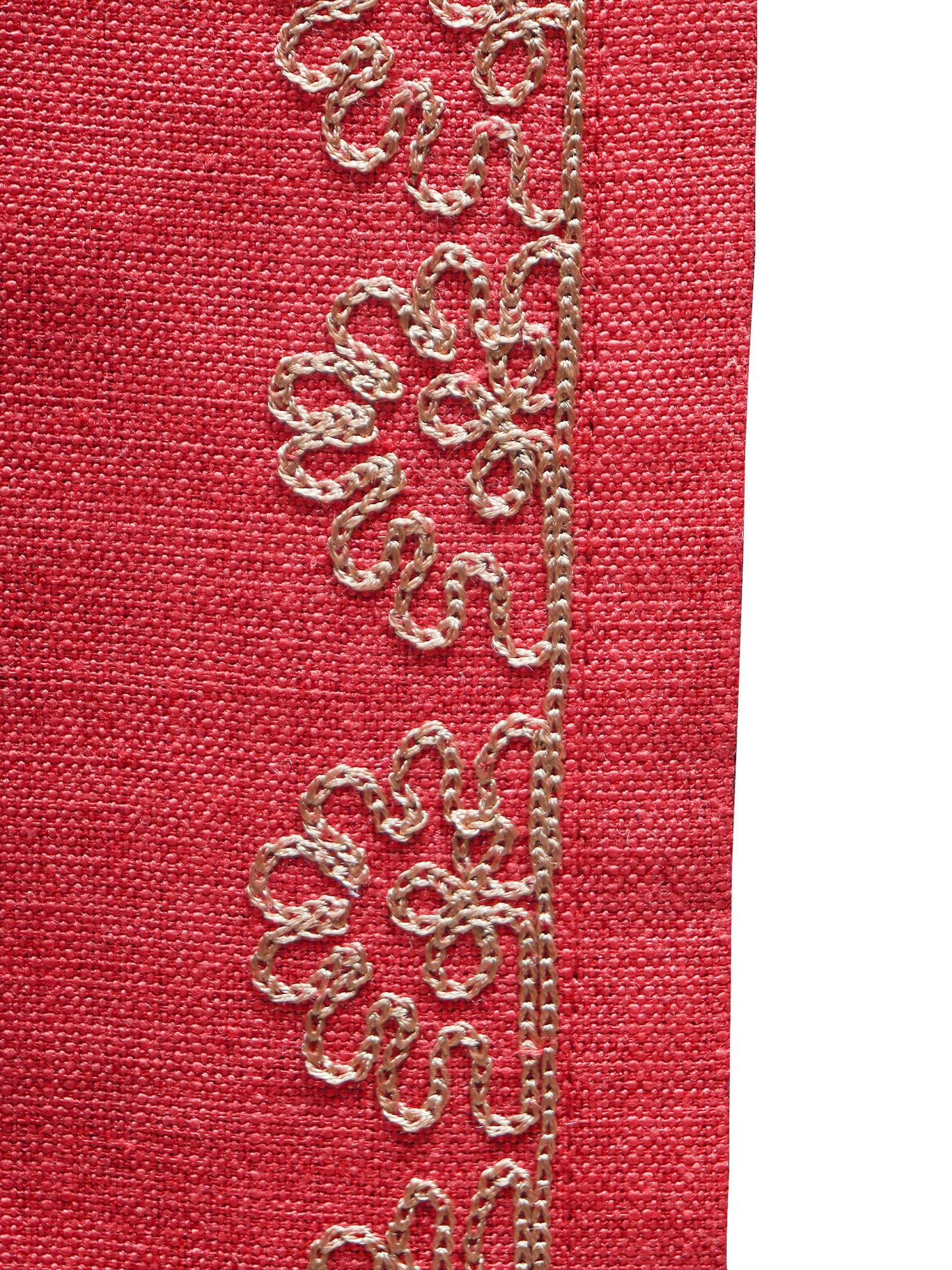 closeup of golden embroidery on red colored tablerunner 