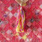 closeup of tassels on pink brocade silk table runner for 6 seater dining table - 12x84 inch