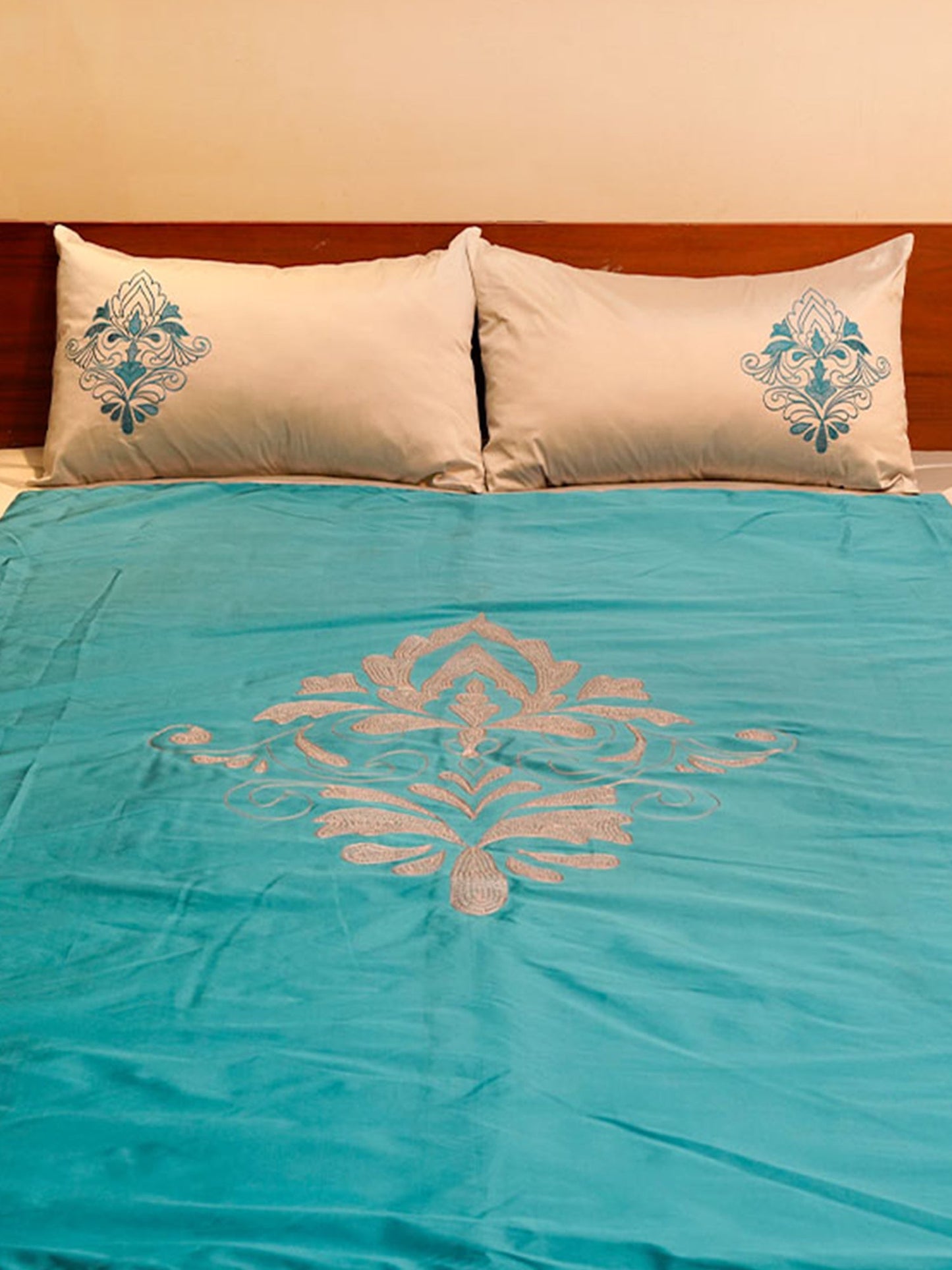 Turquoise blue colored embroidered bed quilt with 2 matching pillow covers made from polyester front adn cotton backed quilt for king size double bed 