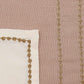 closeup of 4 lines of golden embroidery on beige placemats with border and cotton napkins - 13x19 inch